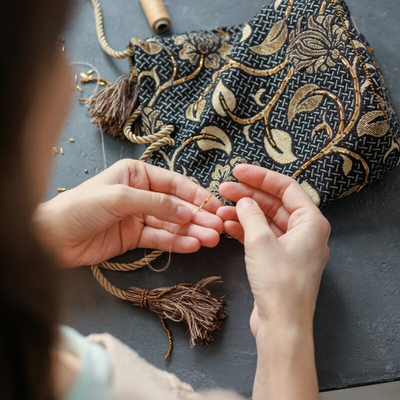 beadwork and embroidery of handmade gold beads and glass beads. women's hands make a bag