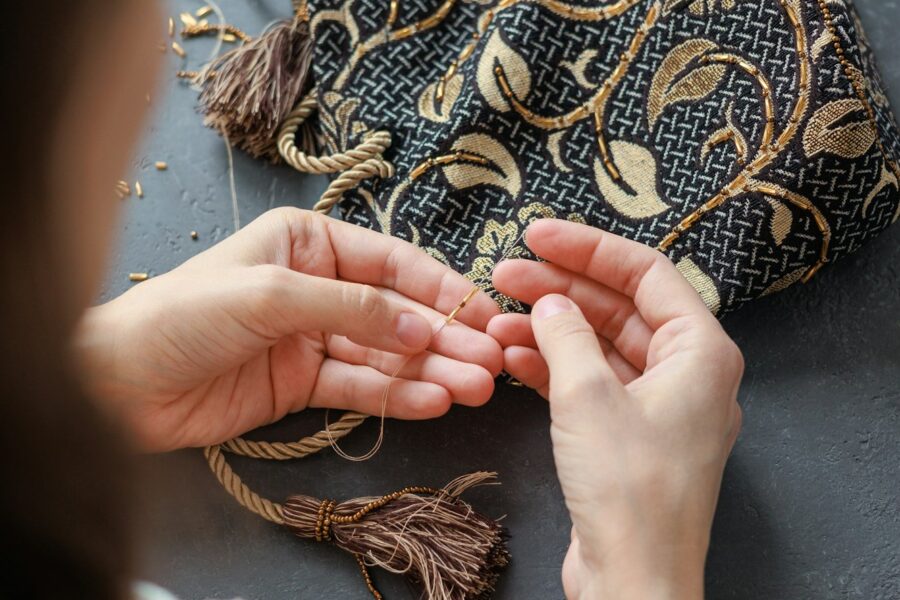 beadwork and embroidery of handmade gold beads and glass beads. women's hands make a bag